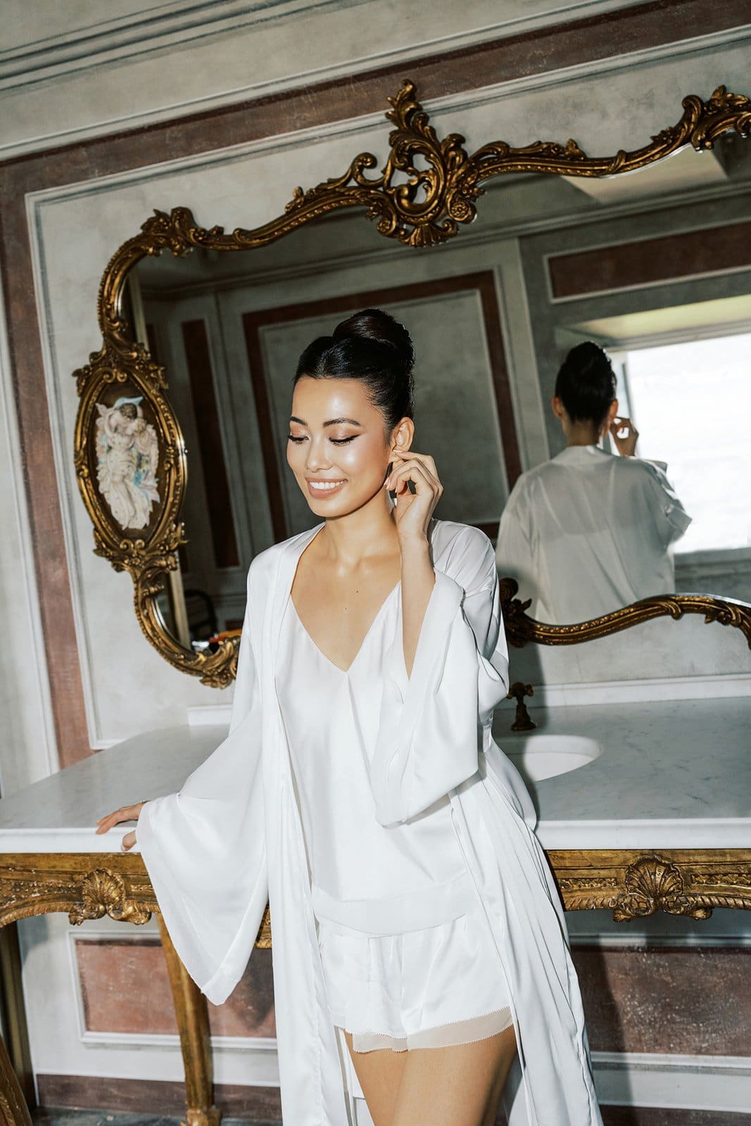 Bride at the mirror at Villa Balbiano, Lake Como, hair and makeup by Botias